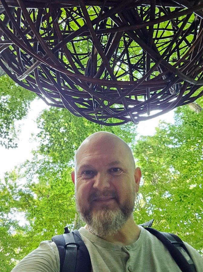 Boris Pecigoš, author of the Land Art Trail on Učka, and his land art - a knitted ball called "Sphere" that "floats" in the treetops
